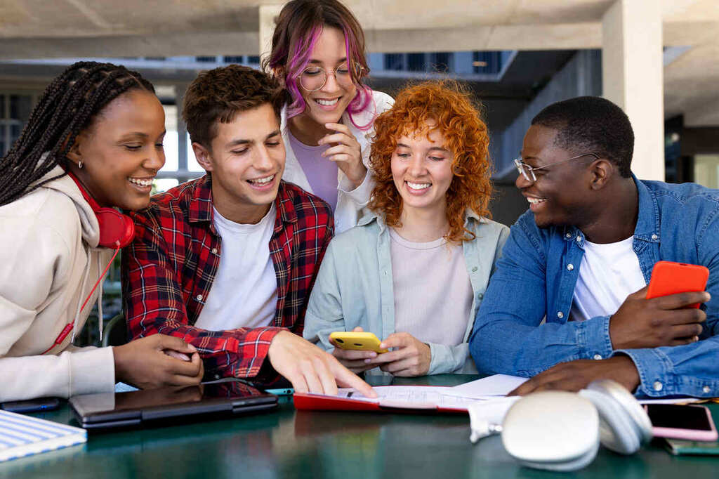 alunos reunidos usando o celular, representando o processo de inscrição no Prouni