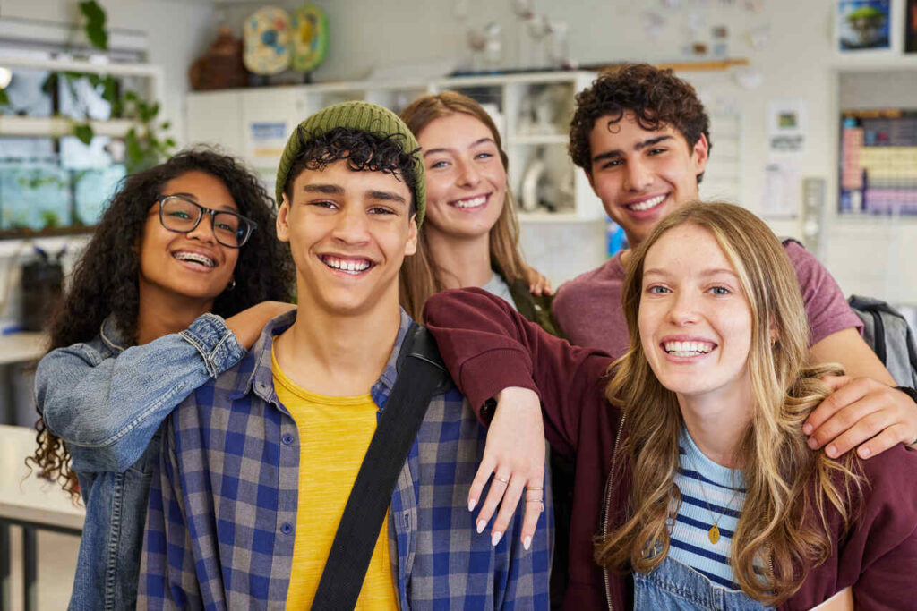 Cinco jovens sorridentes após aprenderem como escolher os cursos de graduação mais procurados.